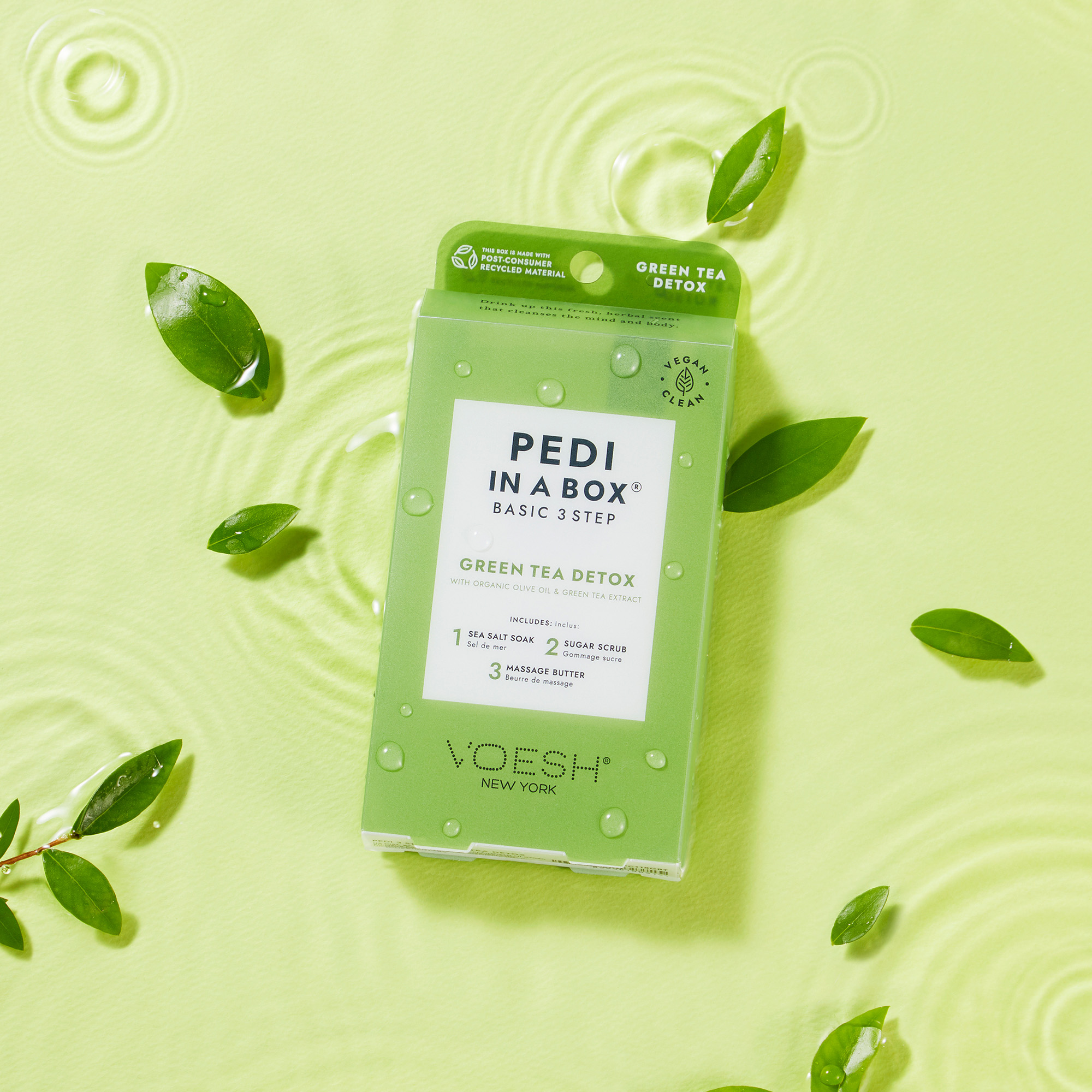 VOESH Pedi in a Box Basic 3 Step Green Tea Detox Pediküre-Set, Packung mit grünen Blättern und Wassertropfen auf hellgrünem Hintergrund