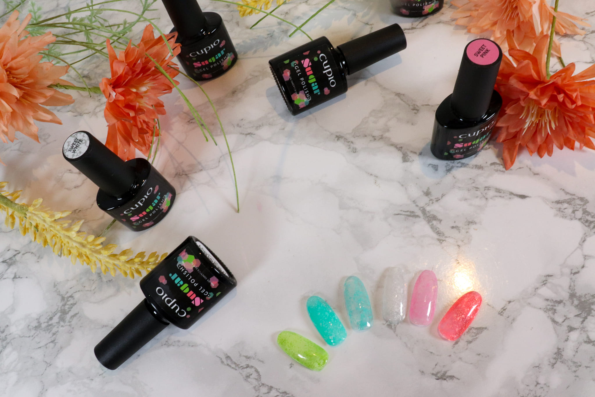 348867497_806776157168425_2107991838570103971_n Verschiedene Cupio Gel Polishes und farbige Nailart Tips auf einer Marmoroberfläche