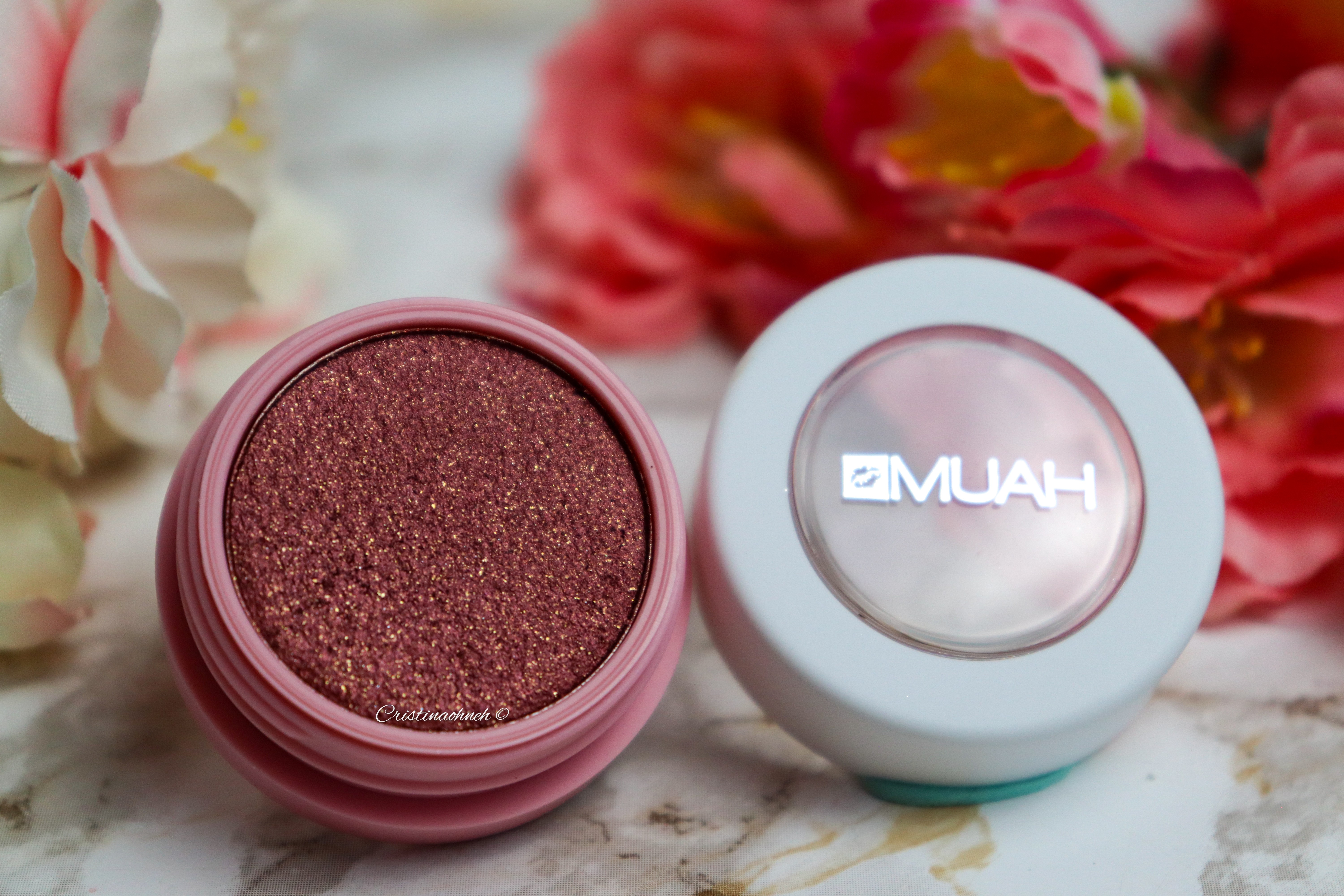 Lidschatten mit glitzernder Textur in einem rosa Farbtönung, präsentiert in einer runden Verpackung.